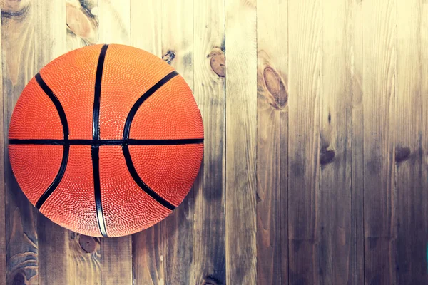 Basketball ball on wooden hardwood floor.