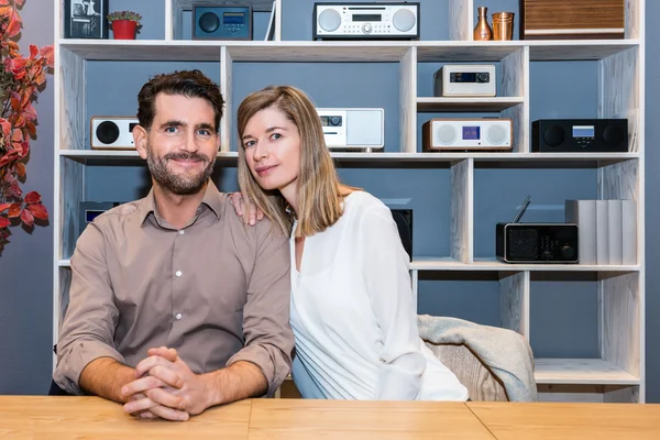 Couple At Counter Against Shelves With Speakers At Shop