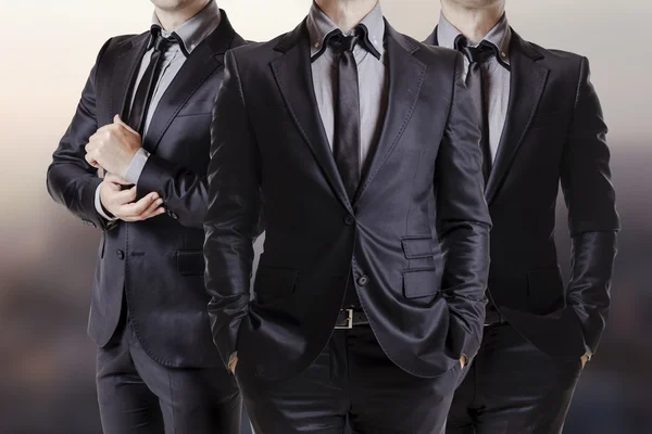 Close up image of three business men in black suit