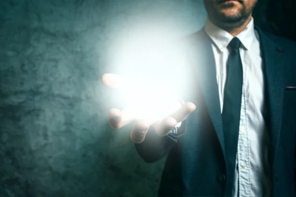 Business vision concept with businessman holding light in hand