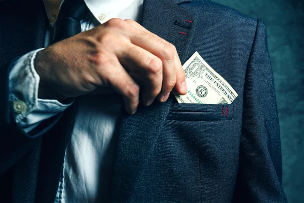 Businessman putting dollar banknotes money in his suit pocket