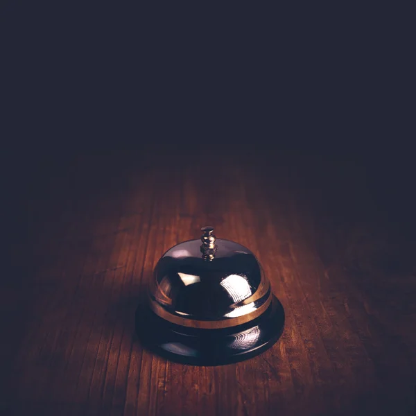 Hotel service call bell on wooden reception front desk