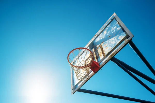 Plexiglass street basketball board with hoop on outdoor court