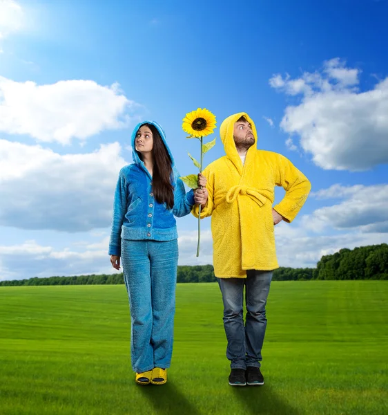 Strange couple holding sunflower