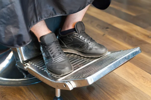 Man's legs in barber chair