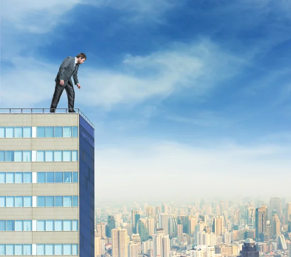 Businessman looks down from  building
