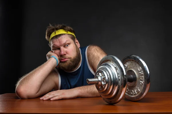 Sad fat man with dumbbell