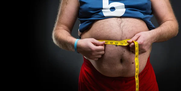 Fat man measuring big belly