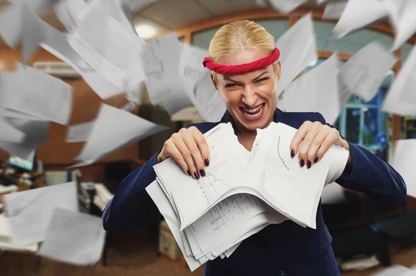 Angry businesswoman tearing papers
