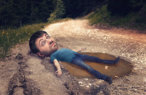 Man with big head in puddle