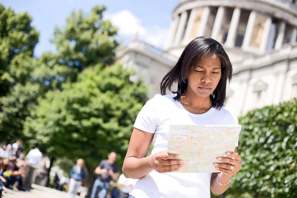 Young woman reading a map in London
