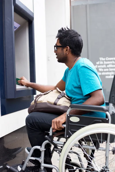 A young indian man in a wheelchair
