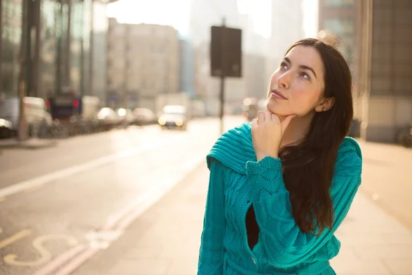 Young woman looking up thoughtful