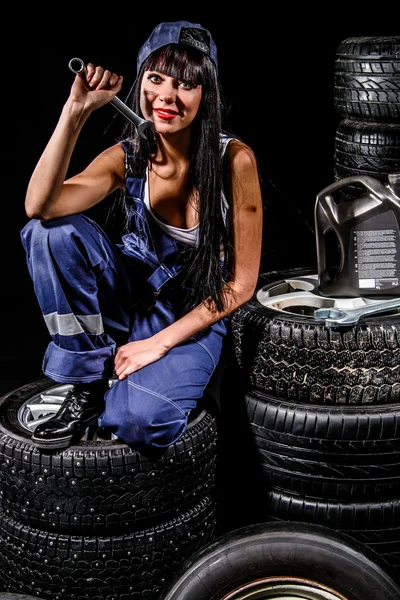 Sexy young woman sitting on a tires