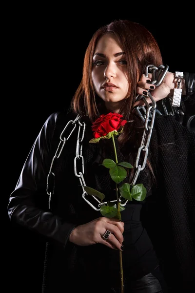 Beautiful young woman with chains and a red rose