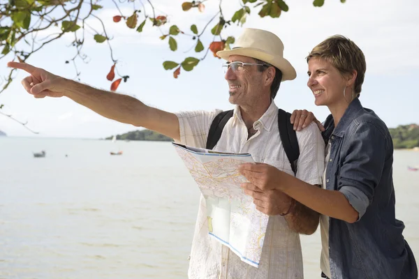 Middle aged couple on vacation with map