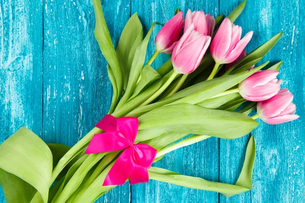 Beautiful pink tulips on blue wood background