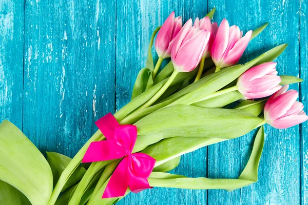 Beautiful pink tulips on blue wood background