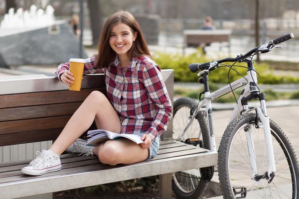 Young woman drinking coffee on a bicycle trip