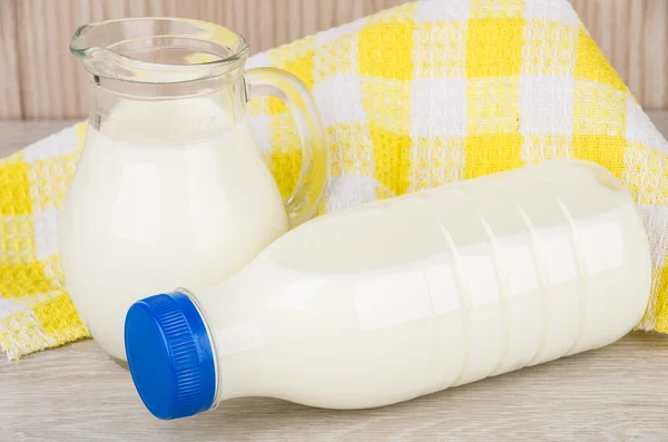 Milk in glass jug in plastic bottle with napkin