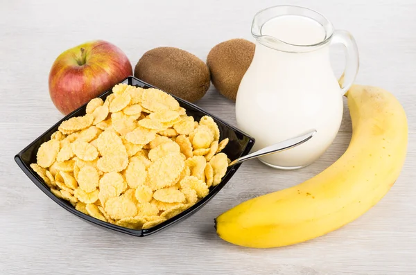 Jug of milk, bowl with corn flakes and fruits