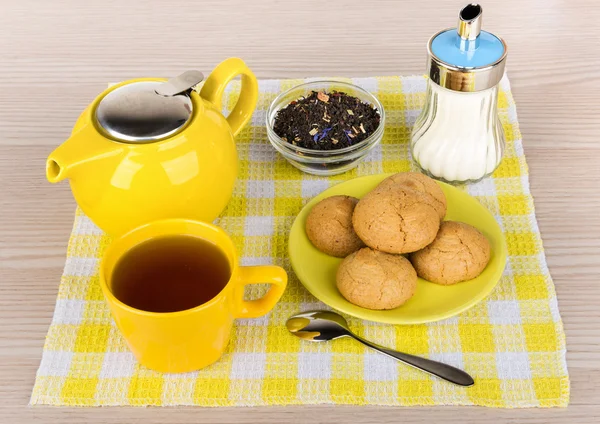 Kettle and cup of hot tea, sugar and biscuits