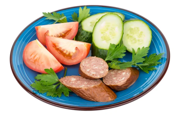 Plate with pieces of sausage, tomatoes, cucumbers and parsley