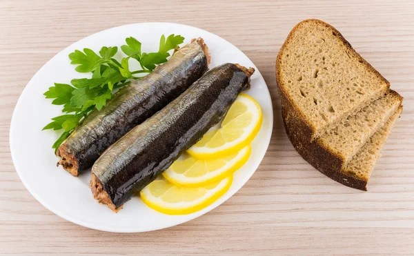 Canned fish with lemon and parsley in plate and bread