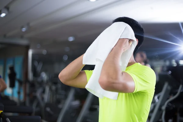 Asian boy with towel in modern gym