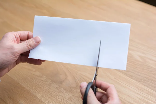 Businessman cutting paper by scissors