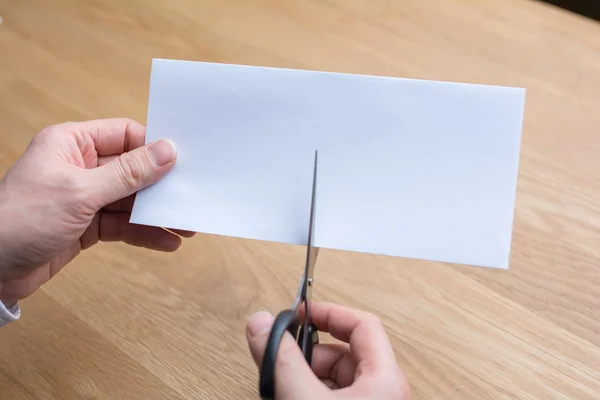 Businessman cutting paper by scissors