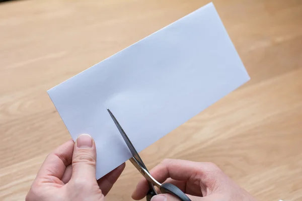 Businessman cutting paper by scissors