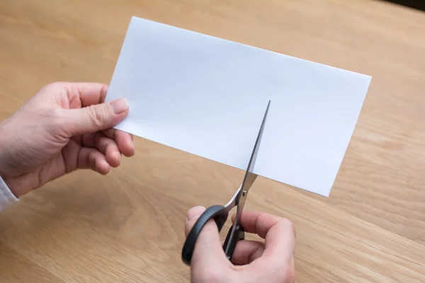 Businessman cutting paper by scissors