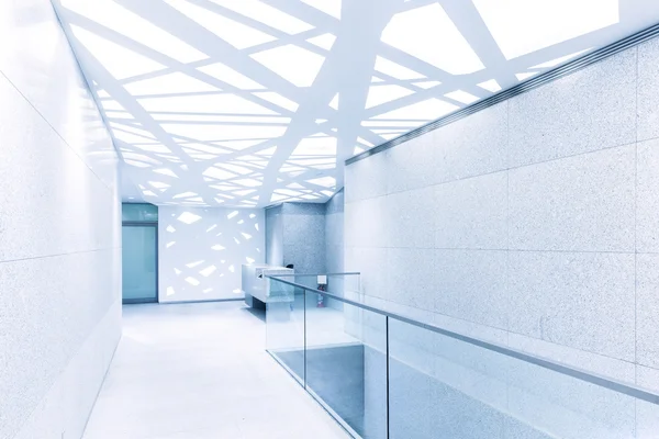 Empty corridor with glass railing and abstract ceiling