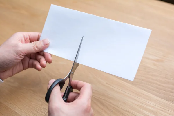 Businessman cutting paper by scissors