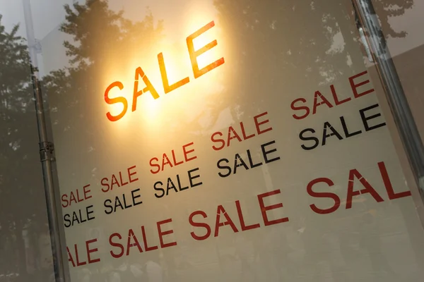 Sale poster in the display window of shop