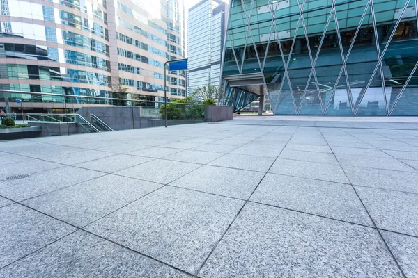 Empty pavement by the side of office building