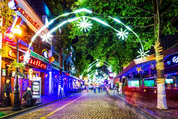 Road across illuminated shopping street