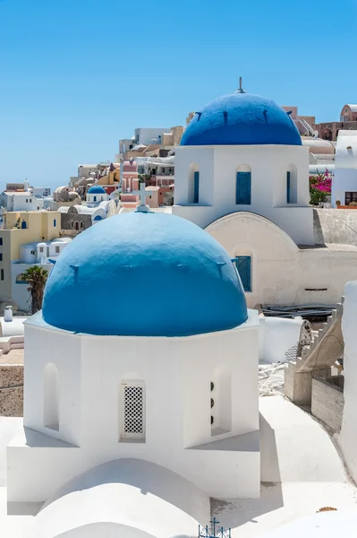 White and blue view of Santorini with two domes