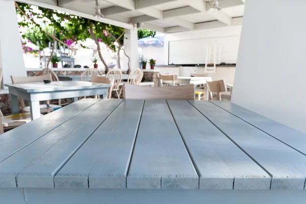 White wooden table with restaurant on background