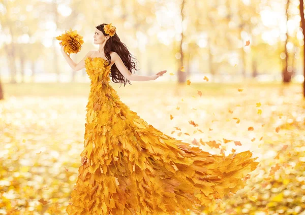 Autumn woman in fashion dress of fall maple leaves, artistic beauty portrait in yellow gown