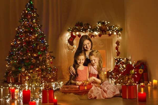 Christmas Family Woman Portrait, Mother And Daughters Celebrate Holiday, Opening Present Gift Box In Room Decorated By Xmas Tree and Candles Lights