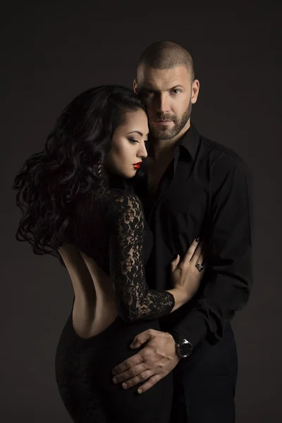 Couple Man and Woman in Love, Fashion Beauty Portrait of Models Embracing over Black Background