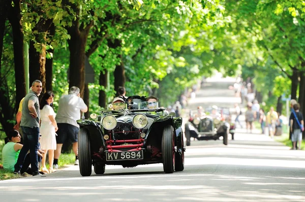 A black and red Riley prototype, followed by OOF classic cars, takes part to the 1000 Miglia classic car race