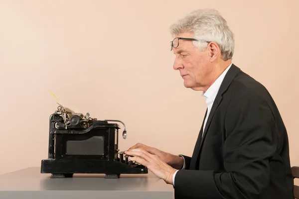 Senior man with antique typewriter