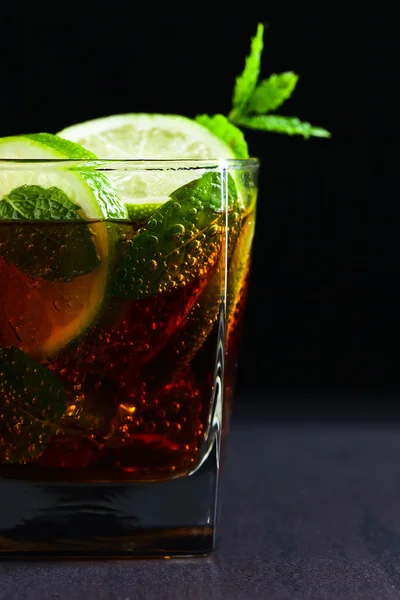 cocktail Cuba libre with lime and peppermint leaves