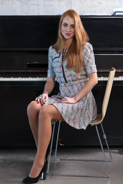 Beautiful woman and old black piano