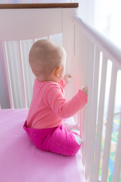 Baby girl sitting in the crib