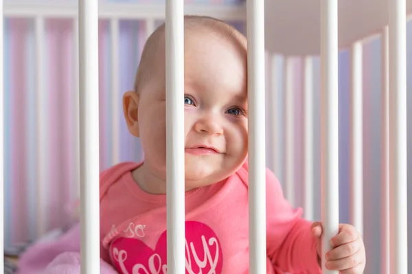 Baby girl sitting in the crib