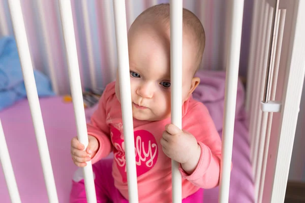 Baby girl sitting in the crib